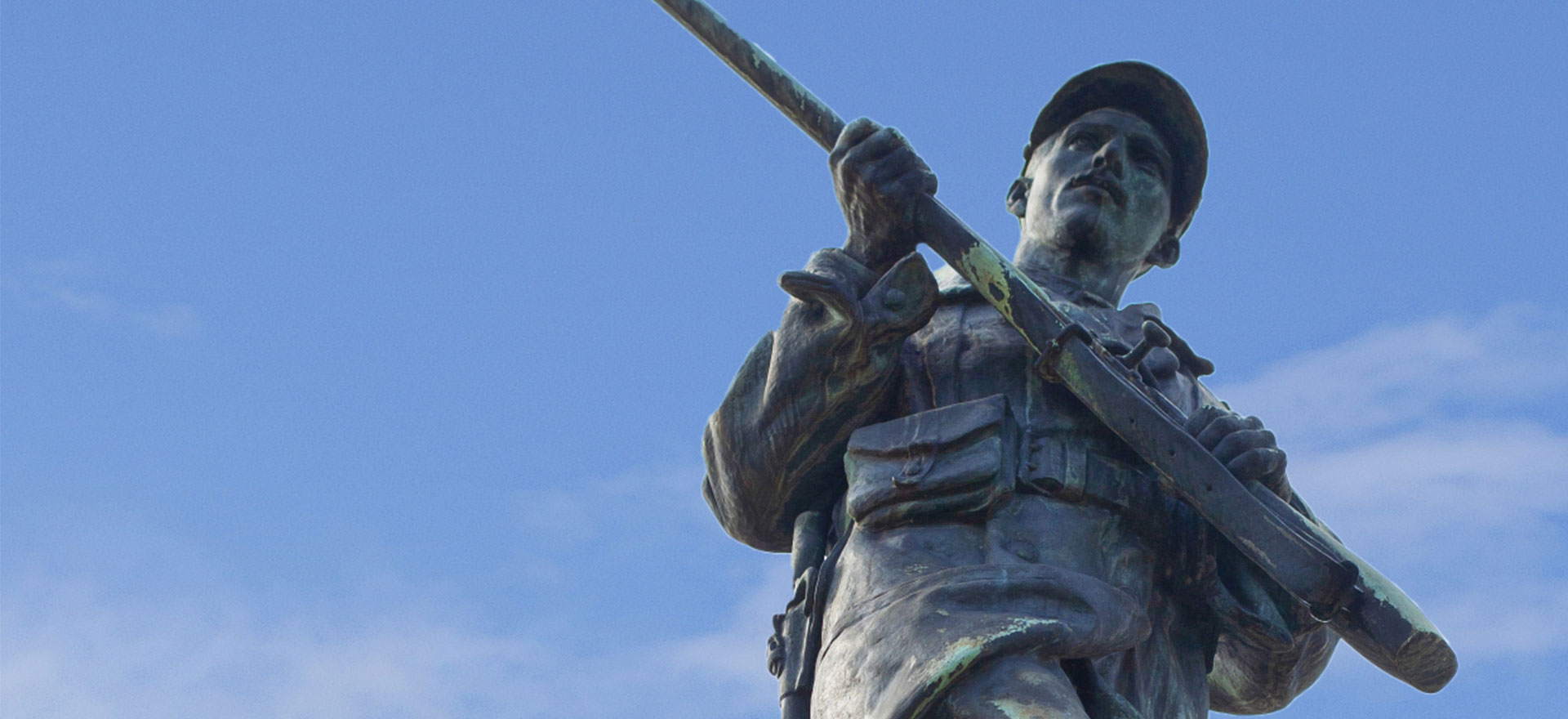Statue d'un soldat en bronze avec un ciel bleu